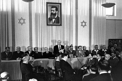 David Ben-Gurion reading the Declaration of the Establishment of the State of Israel on May 14, 1948 in the Dizengoff house in Tel Aviv. To Ben-Gurion’s right is Rabbi Yehuda Leib (Fishman) Maimon. Photo: The State of Israel National Photo Collection/Kluger Zoltan 