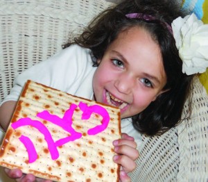 A student at Hyman Brand Hebrew Academy in Kansas City taking a bite out of her matzah project.