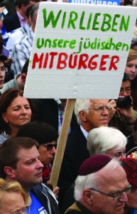 A demonstrator holds a sign reading “We Love Our Jewish Fellow Citizens” in German during a rally against anti-Semitism on September 14, 2014, in Berlin, Germany. With the slogan “Stand Up! Never Again Hatred Towards Jews” (“Steh auf! Nie wieder Judenhass”), the Central Council of Jews in Germany (Zentralrat der Juden) organized the demonstration after anti-Semitic incidents in the country occurred in the wake of the conflict in Gaza that summer. Photo: Adam Berry/Getty Images