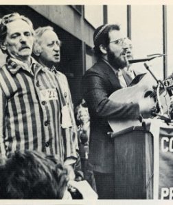 Cantor Goffin performing with his guitar at a Soviet Jewry rally with two Russians dressed in prisoner uniforms, circa 1970. Courtesy of Cantor Goffin
